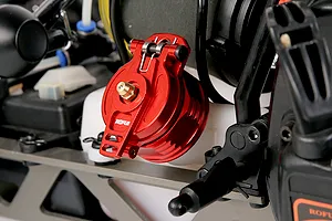 A red anodized aluminium fuel tank cap with a spring-loaded latch installed on an RC car fuel tank.