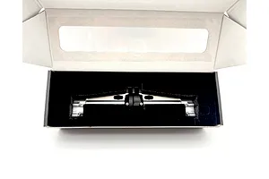 Silver aluminium RC axle housing in a cardboard box with black foam insert.