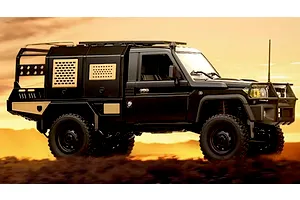 Black MN Model Toyota LC79 RC rock crawler truck parked on a dirt hill against a sunset sky background.