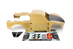 Tan and black painted RC short course truck body shell with separate decal sheet and accessories on a white background.