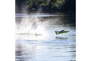 Pro Boat Miss Illinois U-34 RC boat speeding across a calm lake, creating a large splash of water.
