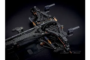 Close-up studio view of the RC Maker SP2 EP RC touring car carbon fibre chassis and suspension components.