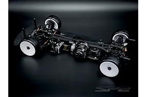 Studio shot of the RC Maker SP2 EP 1/10 electric touring car chassis assembled with electronics on a dark gradient background.