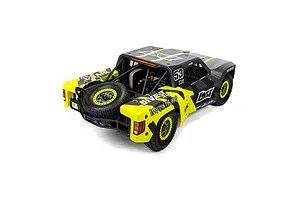 Rear high-angle studio shot of the Losi 5IVE-TG 3.0 1/5 scale petrol short course truck in black and yellow livery with a spare tire.