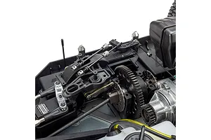 Close-up studio view of the internal chassis, steering linkage, gears, and servo of a 1/5 scale petrol RC truck.