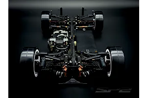 Top-down rear view of the RC Maker SP2 EP RC touring car chassis featuring carbon fiber, black components, and bronze accents on a dark background.