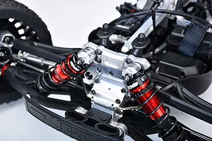 Close-up view of silver aluminium shock cap protectors installed on an RC car suspension system with red dampers.