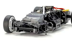 Close-up studio shot of the RC car chassis showing front suspension, wheels, and internal components against a white background.