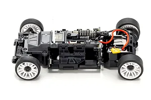 Top down view of an assembled black RC car chassis with white wheels and electronic components on a white background.
