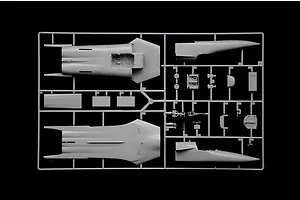 A grey plastic model kit sprue containing aircraft fuselage halves and various smaller detail parts against a black background.