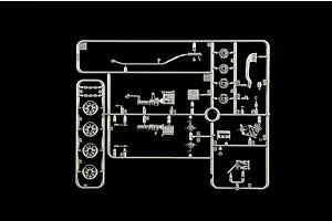 Grey plastic model kit parts sprue containing engine and wheel components on a black background.