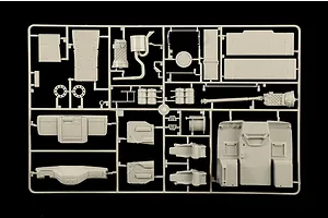 Molded grey plastic model sprue featuring truck interior and chassis parts against a black background.