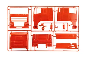 Red plastic model kit sprue containing truck cab body parts and side panels for a 1/24 scale model