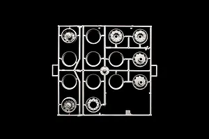 Grey plastic model parts sprue containing truck wheel rims and hub components against a black background.