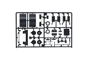 Black plastic model kit sprue containing various truck parts such as fenders, exhaust components, and brackets on a white background.
