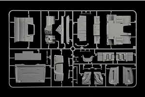 Grey plastic model kit sprue containing various truck interior and body parts on a black background.