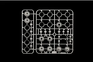 Grey plastic model sprue featuring wheel rims and hubs on a plain black background.