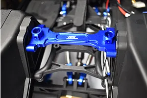 Blue anodised aluminium rear chassis brace installed on an RC vehicle chassis with black plastic components.
