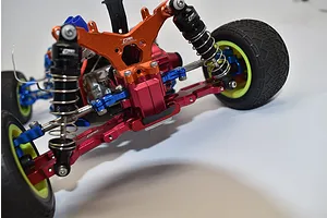 Close-up of the rear chassis and suspension components installed on an RC buggys chassis against a white background.