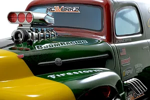 RPM chrome intake and blower set installed on the hood of a scaled RC model truck with green and yellow body.