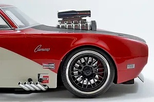 Chrome intake and blower set installed on the hood of a red RC car body against a white background.