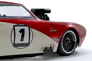 Close-up of a red and white RC car body featuring a black blower scoop protruding from the hood.