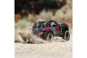 ARRMA Mojave 6S desert truck kicking up dust on a dirt track in an outdoor setting
