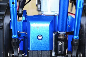Close-up of a blue anodized aluminium lower spur gear case cover installed on an RC model chassis with suspension links.