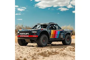 ARRMA Mojave 6S RC short course truck outdoors in a desert environment under a blue sky with clouds.