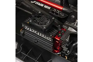 Close-up view of the brushless motor with cooling fan and red anodized aluminum mounts inside an RC short course truck chassis.
