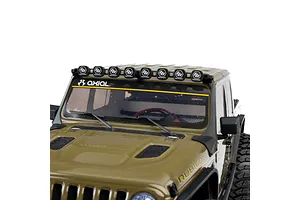Close-up front view of the green Axial SCX10 III RC crawler cab, showing the windshield, wipers, roof light bar, and hood.