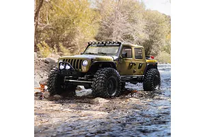 Axial SCX10 III green RC rock crawler driving through shallow water in a natural outdoor environment.