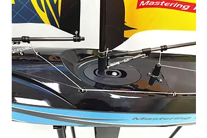 Close-up of the deck and mast rigging on a Joysway Focus V3 RC sailboat with a glossy black hull and blue stripe.