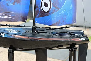 Close-up of the deck, mast, and blue printed sails of the Joysway Orion V2 RC sail boat resting on a stand.