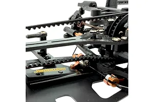 Close-up of RC Maker rear belt tensioner installed on an RC car chassis, showing carbon fibre and aluminium components against a white background.