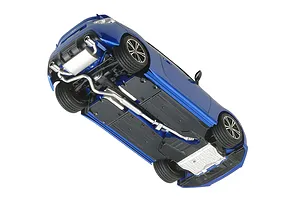 A bottom-up view of a blue Tamiya 1/24 scale Subaru BRZ plastic model car kit showing the chassis, exhaust system, and wheels.