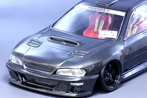 Close-up studio shot of a dark grey Pandora RC Subaru Impreza body shell showing the front end, bonnet vents, and interior seats.