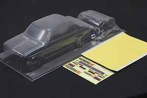 Clear unpainted polycarbonate RC car body shell with separate bumper parts, decal sheet, and masking sheet.