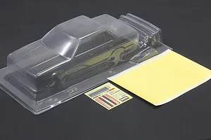 Unpainted clear polycarbonate RC car body shell with a sticker sheet and masking sheet on a dark surface.