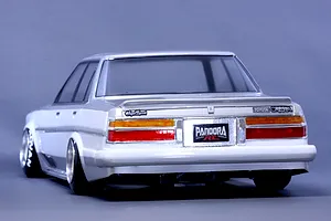 Rear three-quarter view of Pandora RC Toyota Cresta GX71 RC drift body shell in white and silver against a plain studio background.