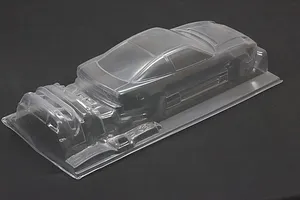 Clear unpainted 1/10 scale RC car body shell showing the rear and side profile on a dark background.