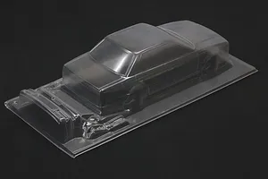 Unpainted clear polycarbonate RC car body shell on a dark background showing the C33 Laurel design.