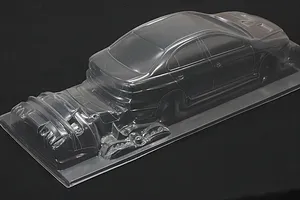 Clear unpainted RC car body shell molded in transparent plastic on a black background