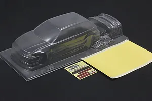 Unpainted clear RC body shell for a Honda Civic EF9 with included mask sheet and decals on a dark surface.
