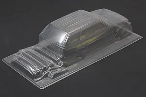Clear unpainted polycarbonate RC car body shell of a wagon displayed on a dark surface.
