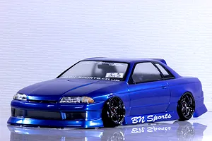 A painted blue Pandora RC HCR32 2Dr BN Sports drift RC car body mounted on a chassis with custom wheels against a white textured background.