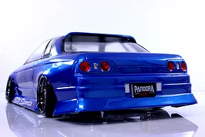 Rear three-quarter view of a blue Pandora RC HCR32 2Dr BN Sports body shell on a drift car with custom wheels against a white background.