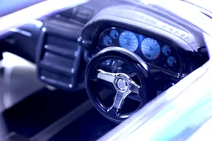 Close-up of a detailed RC car cockpit interior showing a steering wheel, dashboard, and instrument cluster.