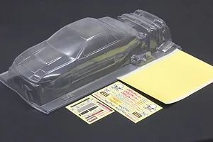 Clear unpainted polycarbonate 1/10 scale RC body shell with separate decal sheets and masking film on a dark surface.
