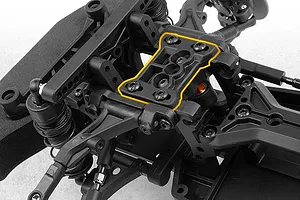Close-up studio shot of an RC car chassis highlighting a specific black plastic top deck component with an orange outline.